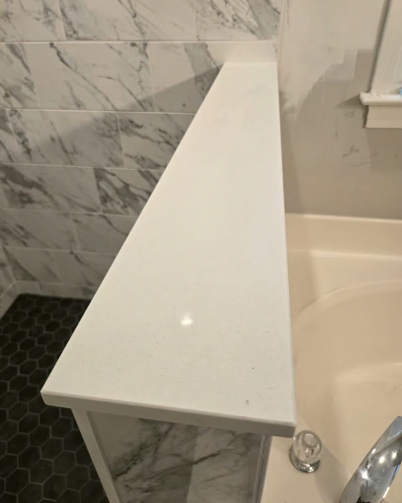 The finished half wall cap that carries the frameless glass panel